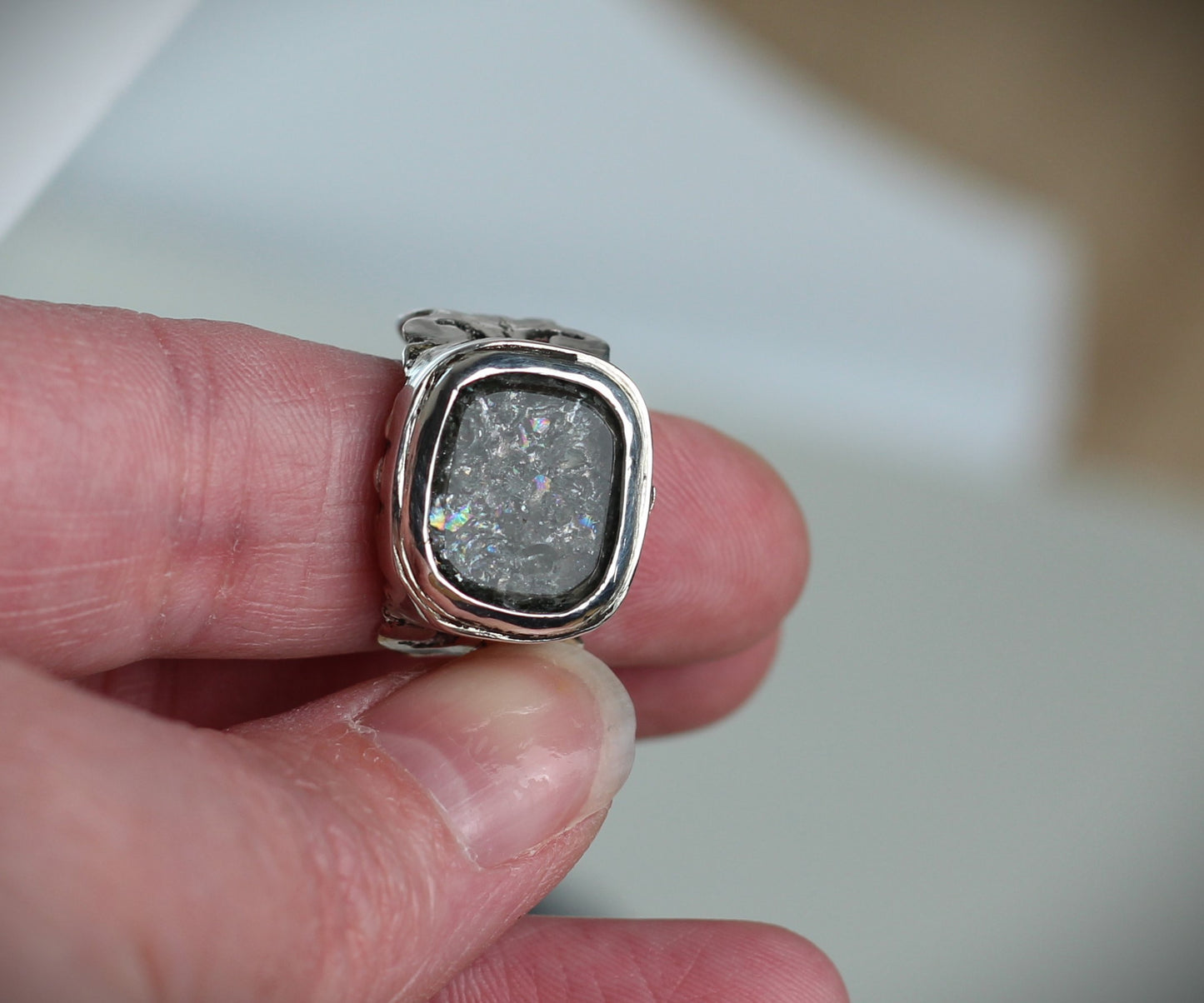 Bergkristall Ring mit schillerndem Regenbogen-Effekt, getragen am Finger