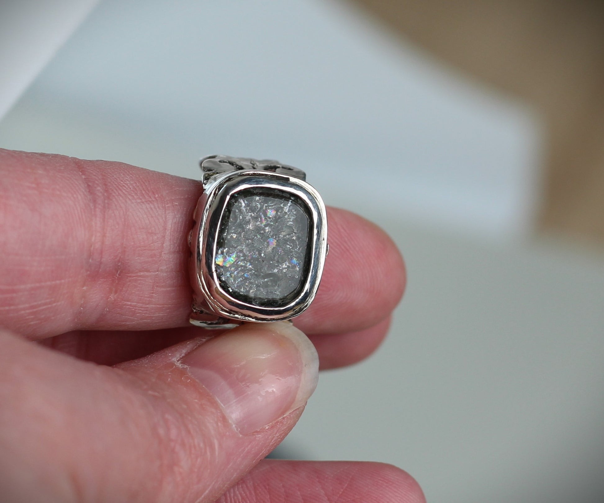 Bergkristall Ring mit schillerndem Regenbogen-Effekt, getragen am Finger